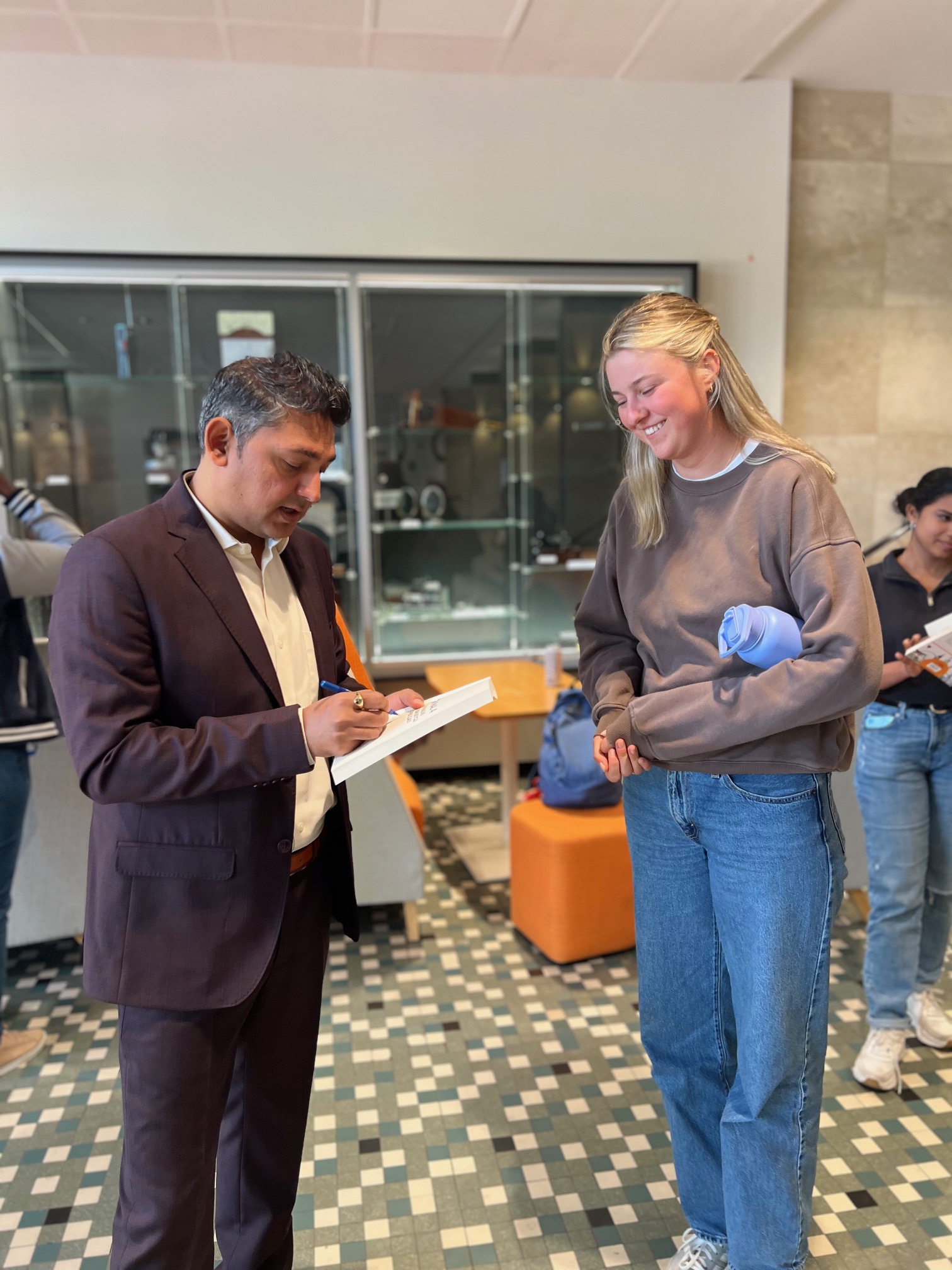 Nilesh Makwana distributing copies of his book to UWA students