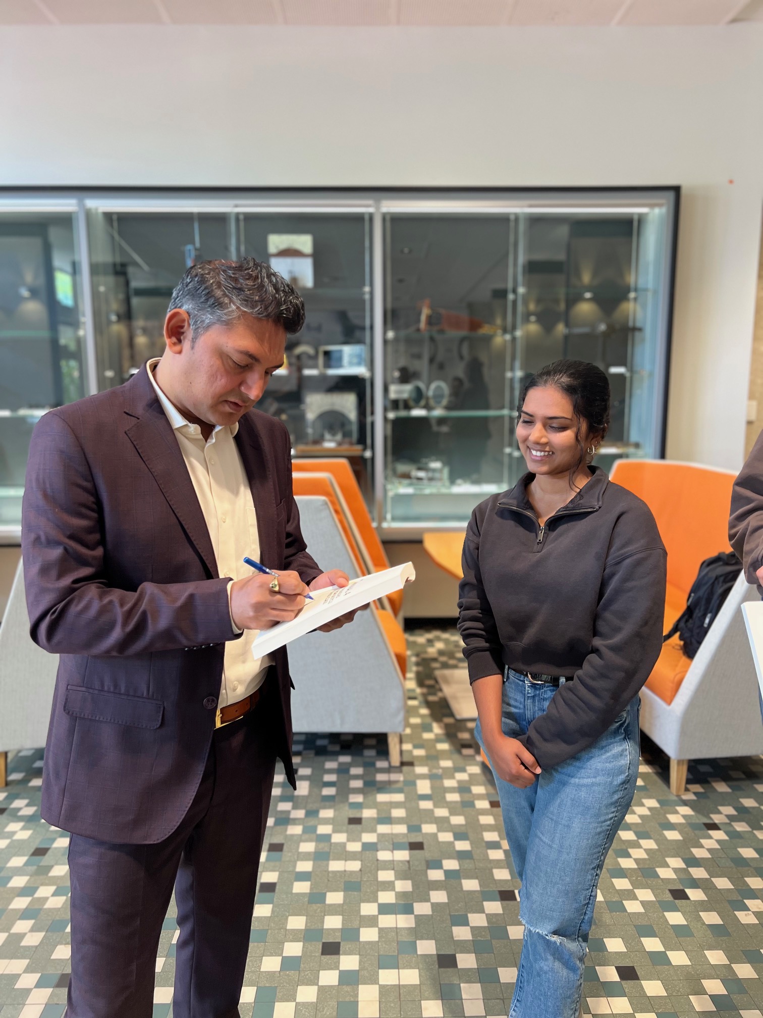 Nilesh Makwana distributing copies of his book to UWA students