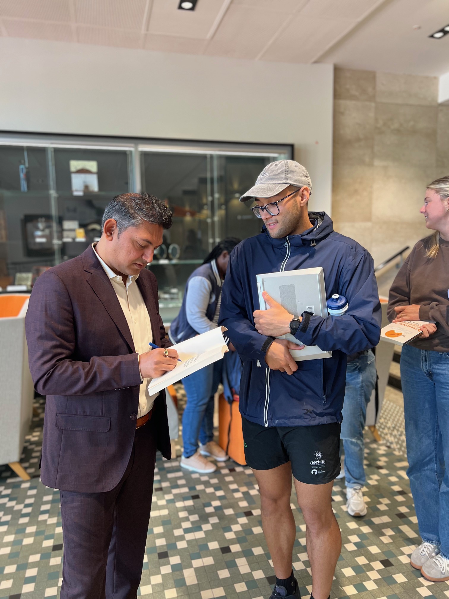 Nilesh Makwana distributing copies of his book to UWA students