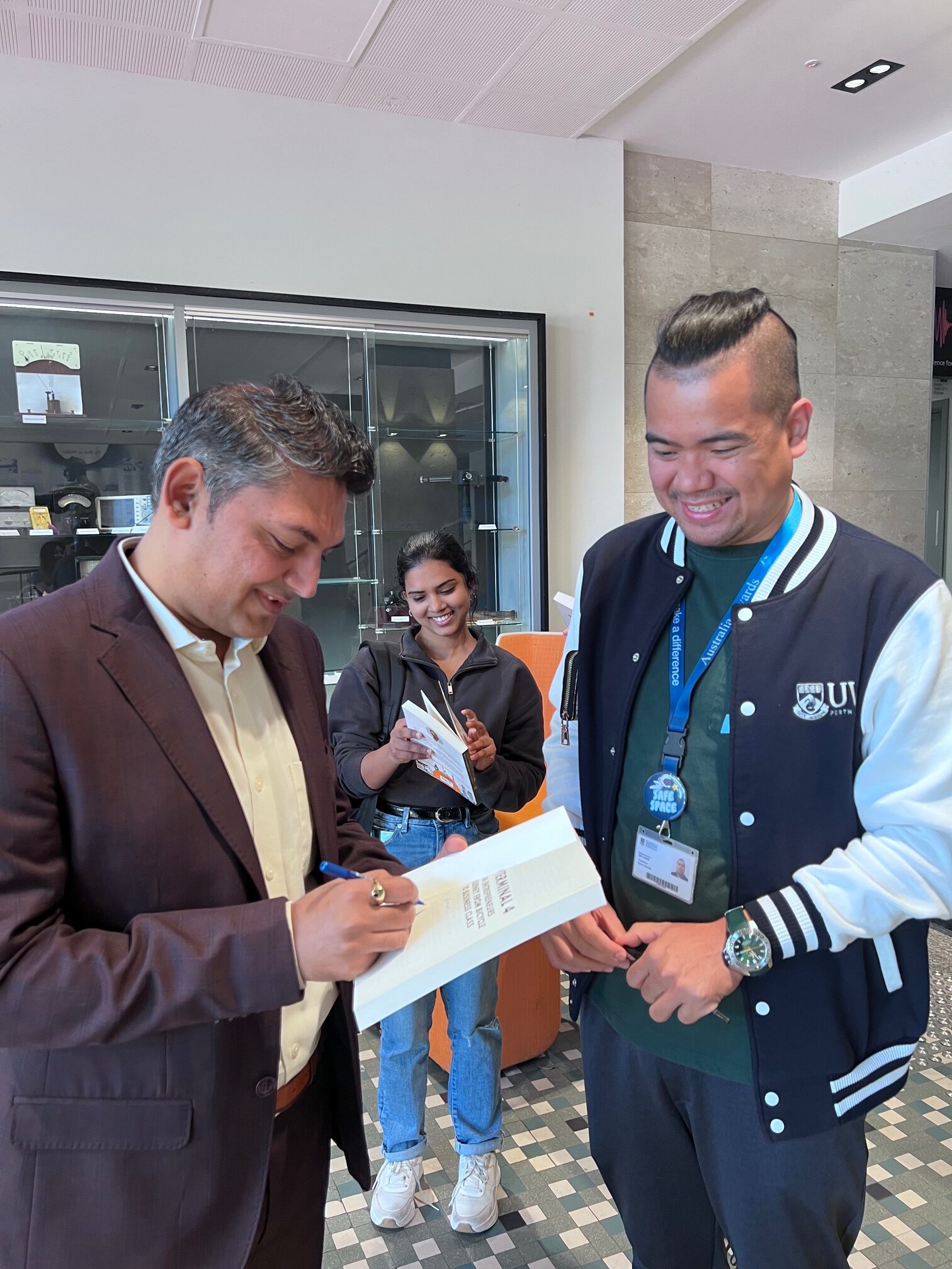 Nilesh Makwana distributing copies of his book to UWA students