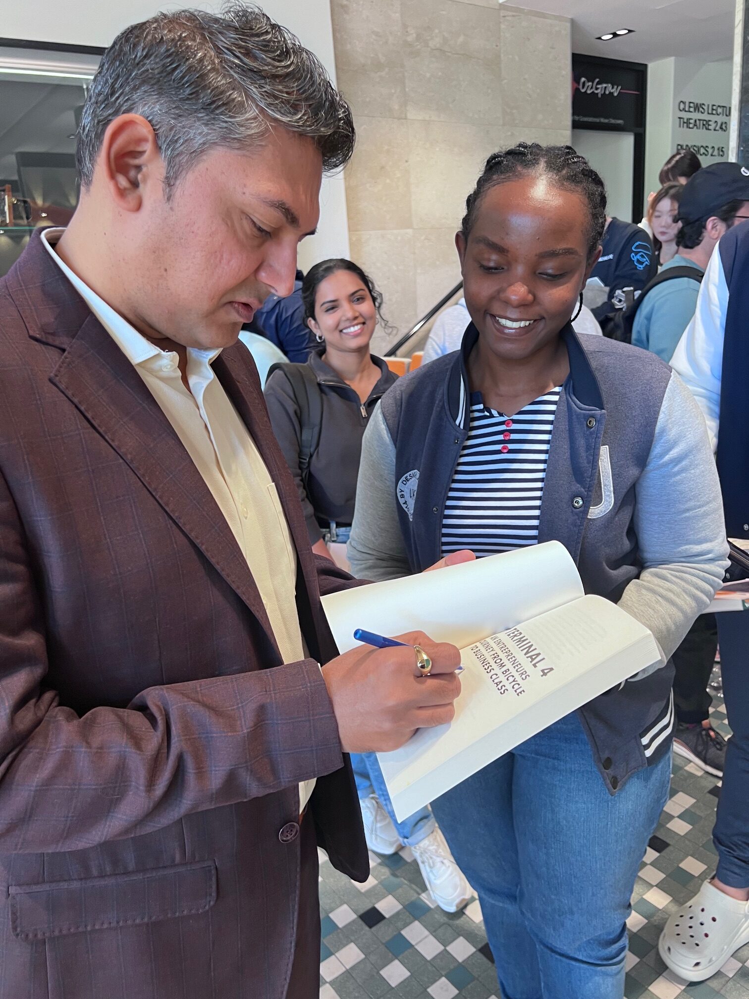 Nilesh Makwana distributing copies of his book to UWA students