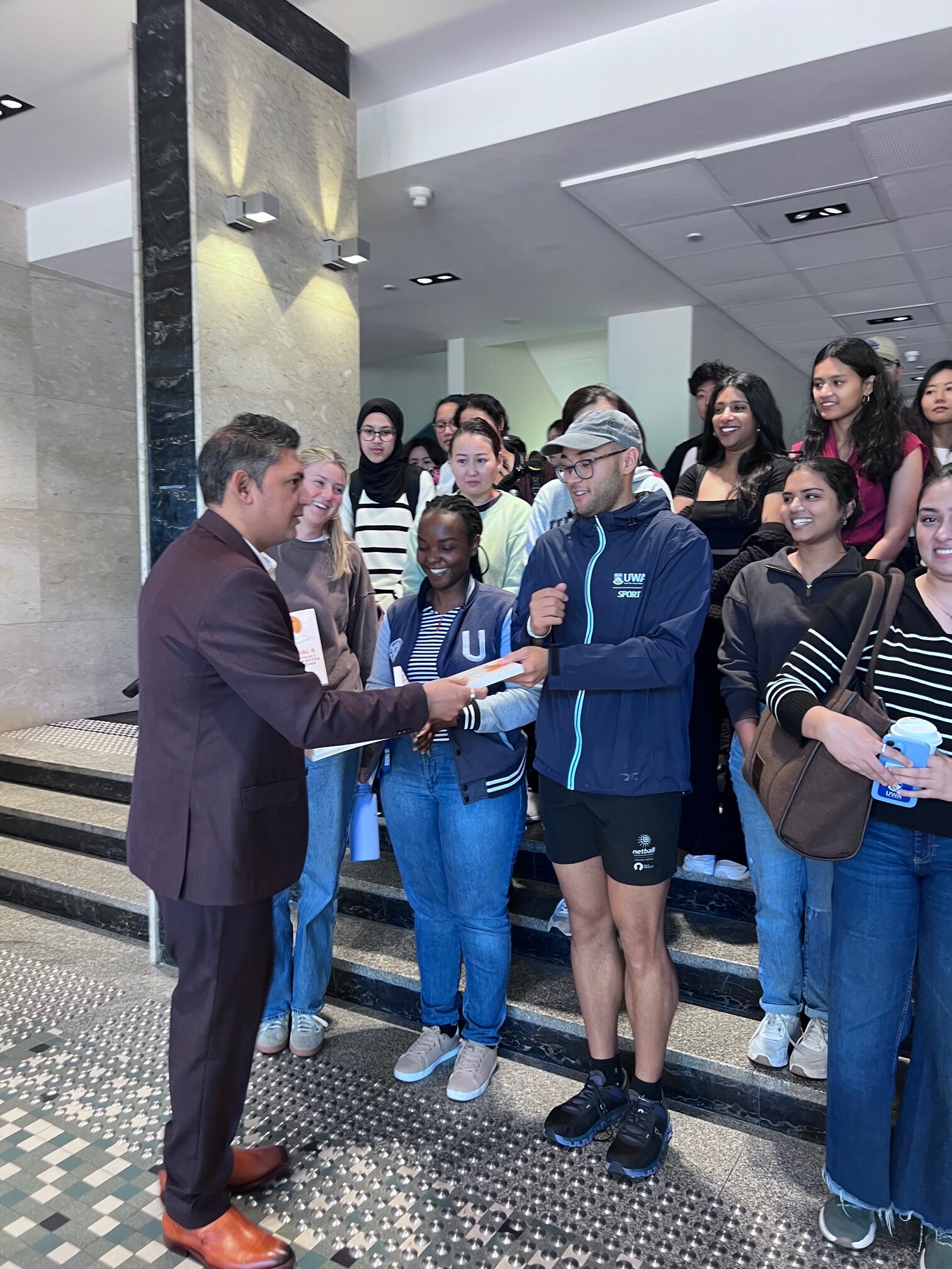 Nilesh Makwana distributing copies of his book to UWA students